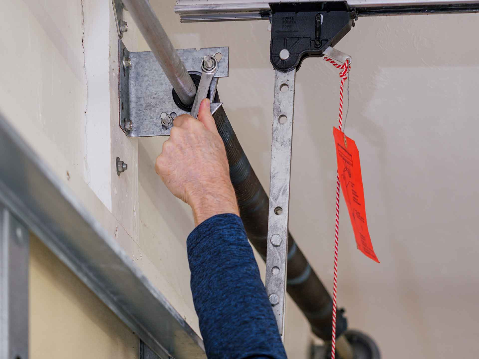 Garage door repair technician fixing a broken garage door spring