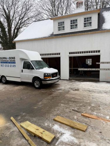 Truck with the Suppa  Sons Overhead Doors logo on a job site
