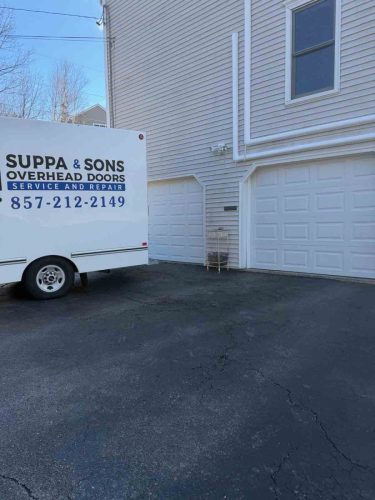 Truck with the Suppa  Sons Overhead Doors logo on a job site